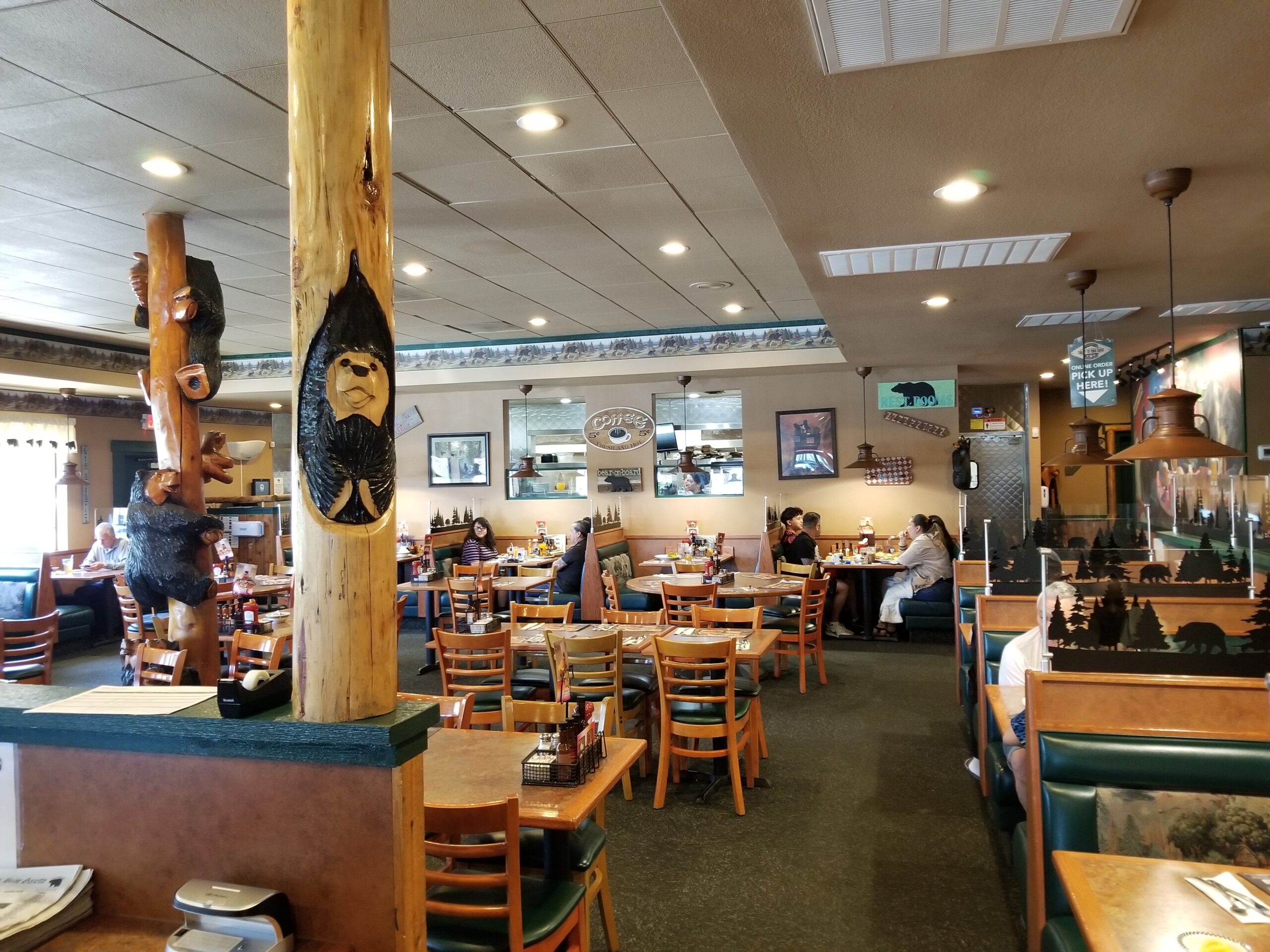 This image shows the dining room at the Black Bear Diner in Las Vegas. It features many pieces of artwork carved from wood with bear motifs.